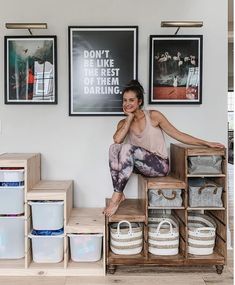 a woman sitting on top of a wooden box next to some baskets and containers in front of her