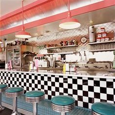 the interior of a diner with checkered counter tops and stools in front of it