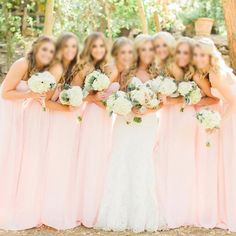 a group of women standing next to each other holding bouquets