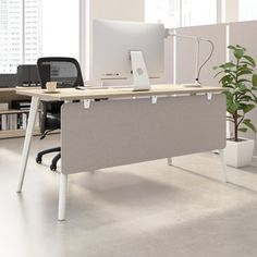 an office cubicle with two desks and a plant