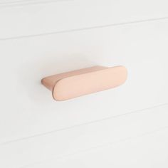 a wooden door handle on a white wall