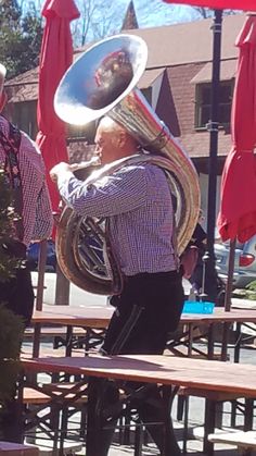 an old man with a large horn on his head is standing in front of a picnic table