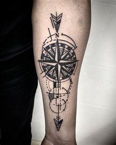 a man's arm with a compass tattoo on the left side of his leg