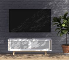 a tv mounted on a brick wall next to a potted plant in front of it