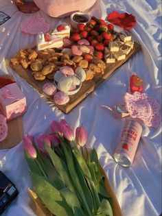 a table topped with lots of different types of food and flowers on top of it