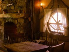 a table and chairs in front of a stone fireplace