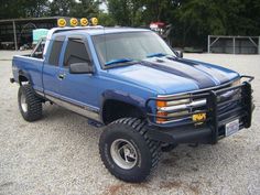 a blue pick up truck parked in a parking lot