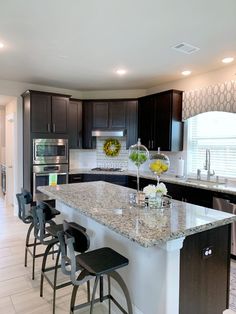 a kitchen with black cabinets and white counter tops