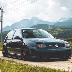 a blue car parked on the side of a dirt road