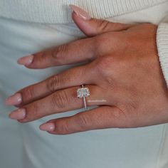 a woman's hand with a diamond ring on it