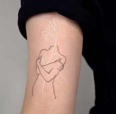 a woman's arm with a tattoo on it that has a line drawing of a girl hugging her arms