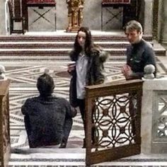 three people standing in front of some stairs