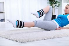 a woman laying on the floor with her legs crossed and wearing striped socks, looking at the camera