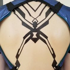 the back of a woman's body with geometric designs on her upper and lower back