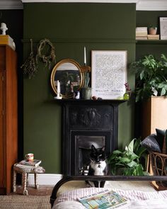 a black and white cat sitting on top of a bed next to a fire place