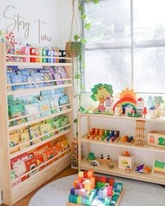 a child's room with toys and bookshelves on the floor in front of a window