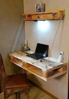 a laptop computer sitting on top of a wooden desk next to a lamp and chair