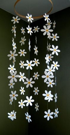 some white flowers hanging from the ceiling in a room with green walls and black flooring