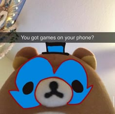 a brown teddy bear wearing a blue hat with the caption you got games on your phone?