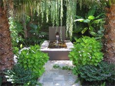 an outdoor fountain surrounded by trees and plants