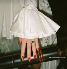 a woman with red nails holding onto a railing