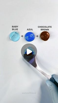 a spoon with chocolate, baby blue and azzul on it next to buttons