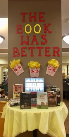 the book was better display with popcorn and movie tickets on it's table in front of a sign that says, the book was better