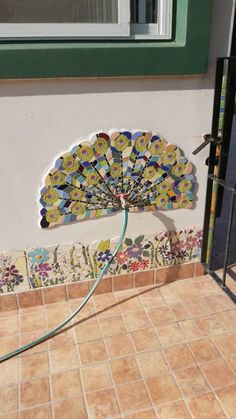 a decorative fan sitting on the side of a building next to a door and window