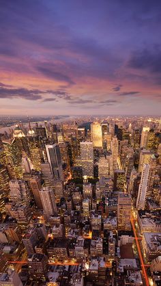 an aerial view of a city at night with the lights on and skyscrapers lit up