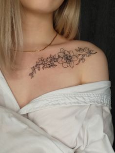 a woman with a flower tattoo on her chest