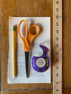 a pair of scissors and tape measure sitting on top of a piece of paper