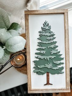 a wooden frame holding a paper cut out of a pine tree