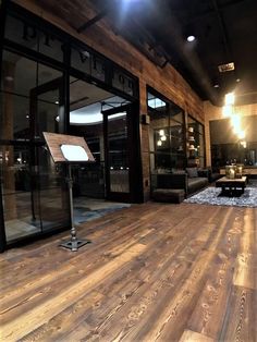 an empty room with wooden floors and glass doors on the walls, lighting from above