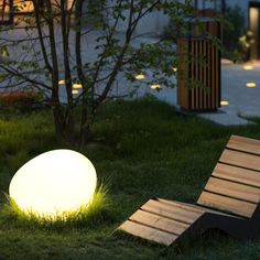 a lawn chair sitting in the grass next to a glowing ball