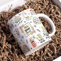 a white coffee mug sitting on top of wood shavings in a box with the words make today written on it