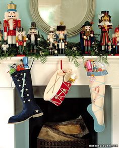 christmas stockings hanging from the mantel with nutcrackers on top