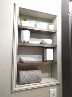 a bathroom shelf with towels and plants on it