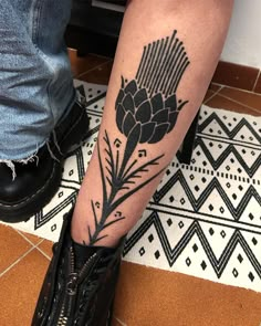 a person with a flower tattoo on their leg