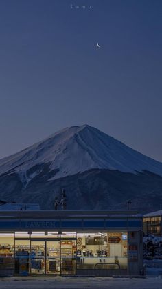 a large mountain in the distance with a store on it's side at night