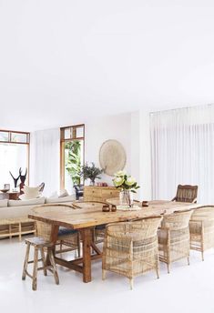 a living room filled with lots of furniture next to a large wooden table and chairs