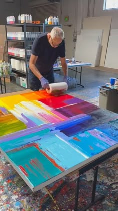 a man working on an art project with multiple colors