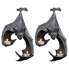 two metal bats holding candles in their claws