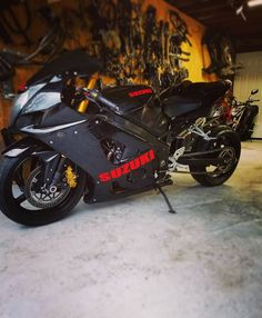 a black motorcycle parked in a garage next to other motorcycles