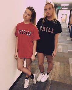 two young women standing next to each other in front of a wall with the word netflix on it