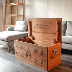 a wooden box sitting on top of a hard wood floor next to a gray couch