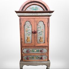 an old wooden cabinet with painted designs on the doors and drawers is shown against a white background