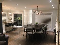 a dining room table and chairs in front of an open kitchen