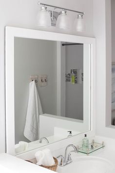 a bathroom with a sink, mirror and soap dispenser