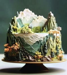 a cake decorated with mountains and trees on a plate