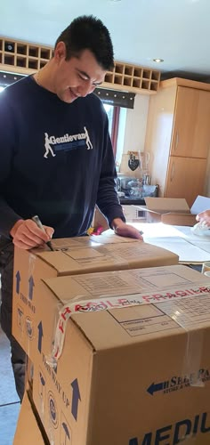 a man standing next to a cardboard box